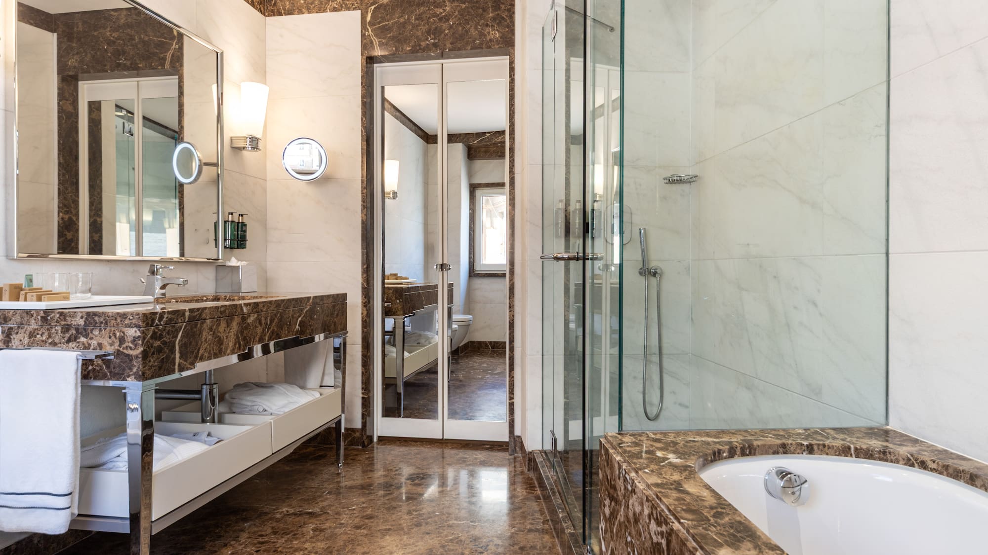 a bathroom with marble countertops and a glass shower