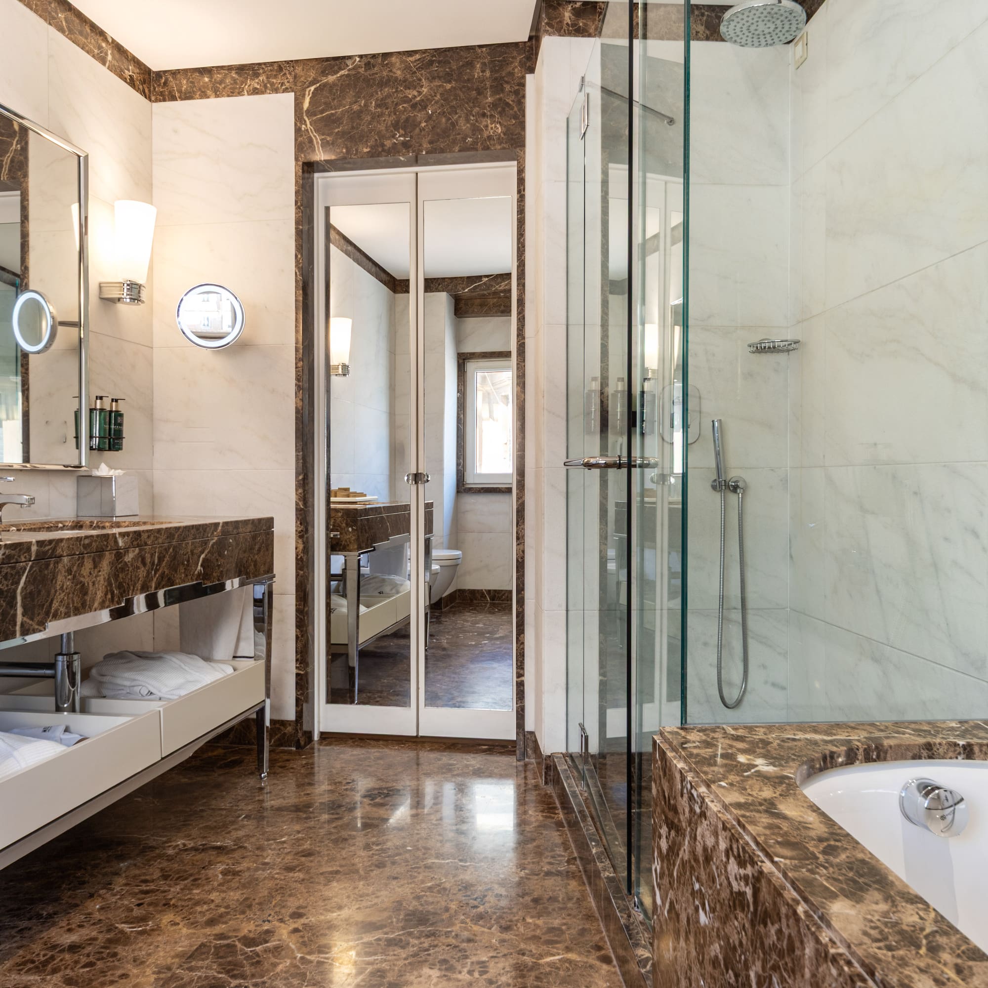 a bathroom with marble countertops and a glass shower