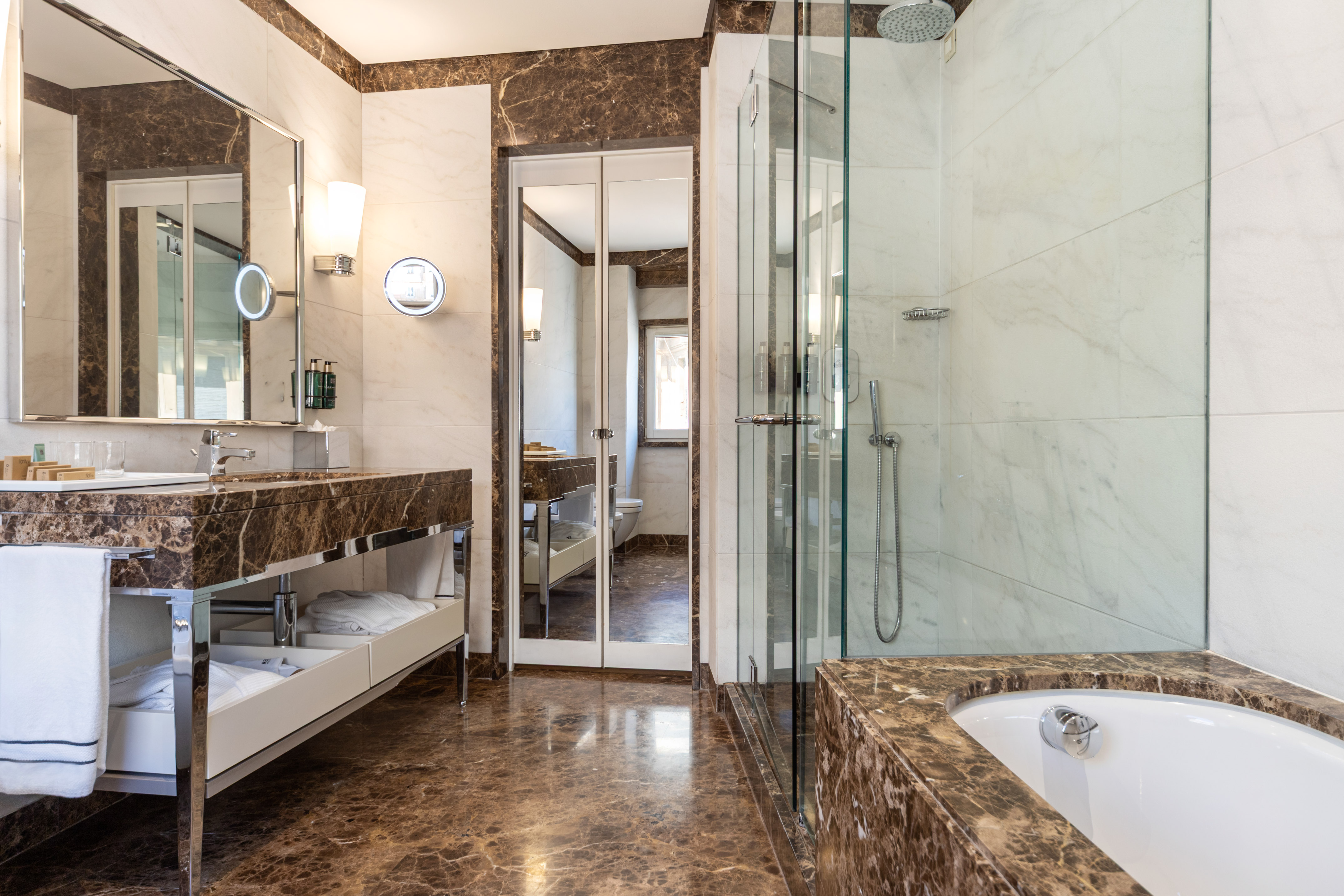 a bathroom with marble countertops and a glass shower