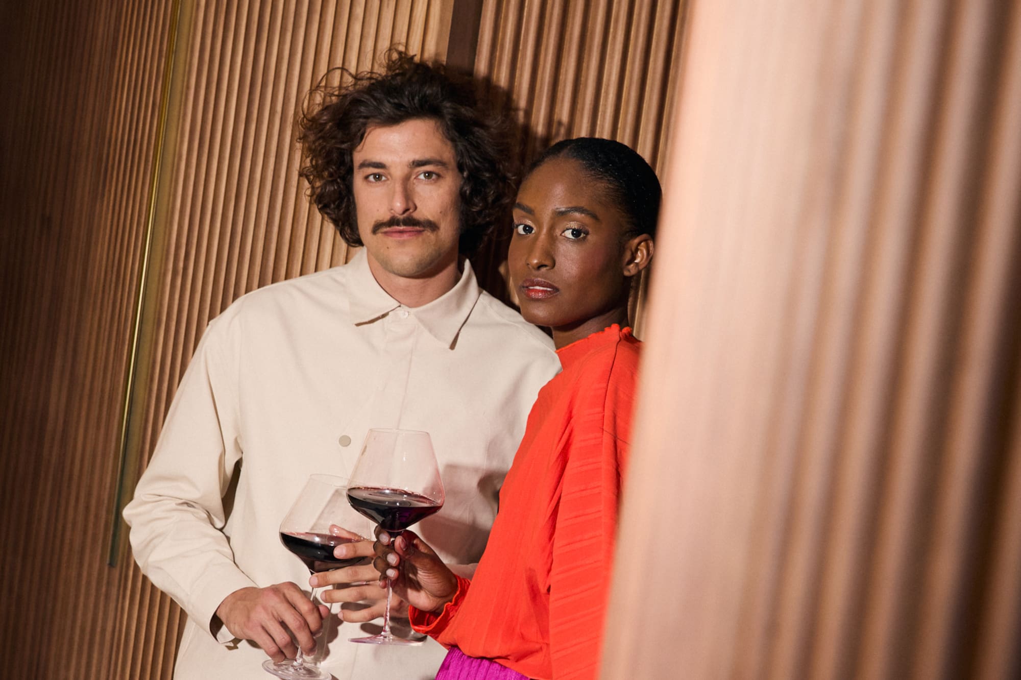 a man and woman holding wine glasses