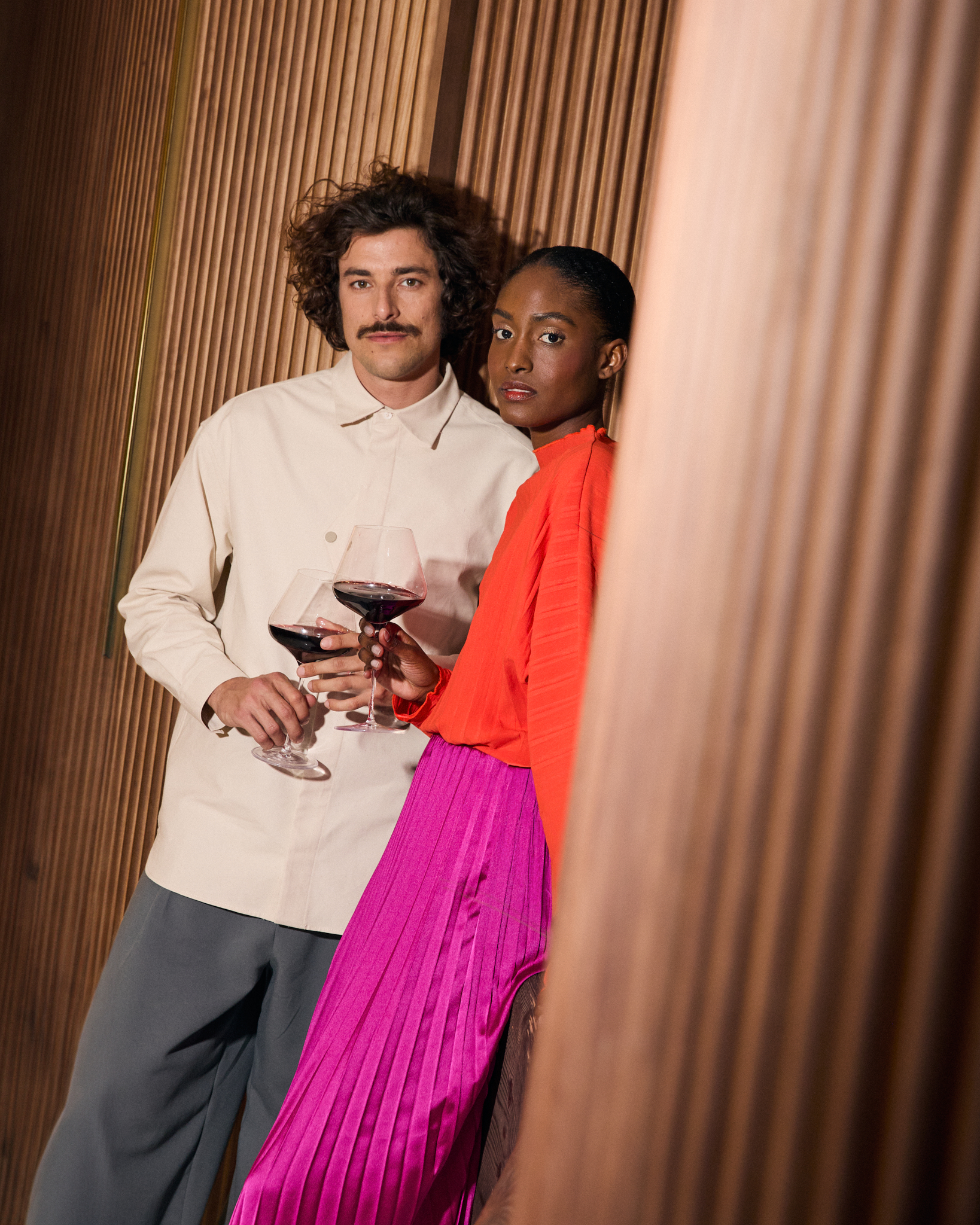 a man and woman holding wine glasses