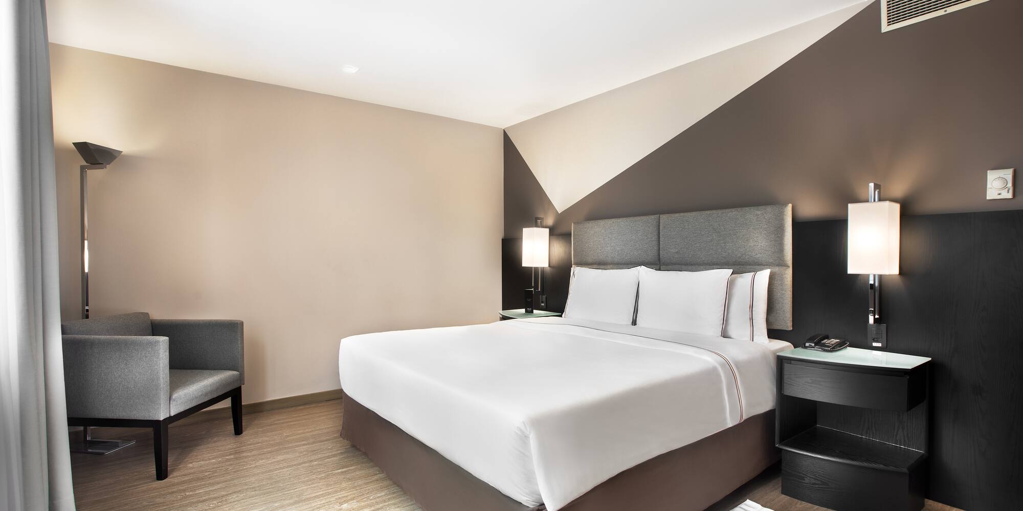 a bedroom with a bed and chairs