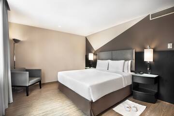 a bedroom with a bed and chairs
