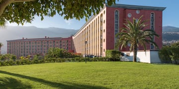 a large building with a lawn and trees