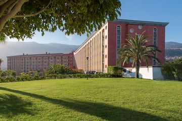 a large building with a lawn and trees