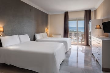 a room with two beds and a balcony