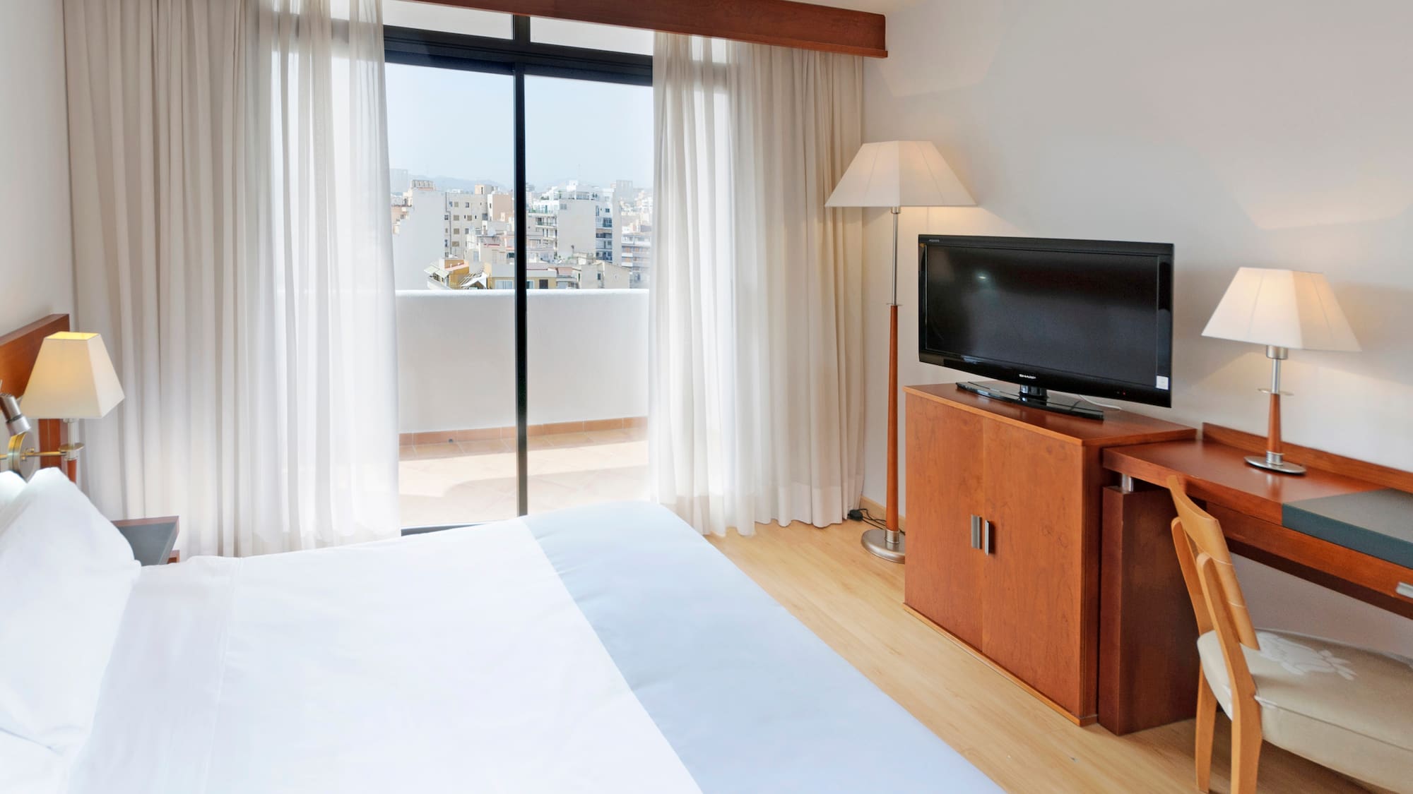 a bedroom with a television and a window