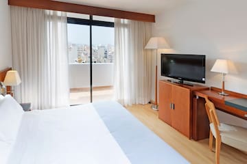 a bedroom with a television and a window