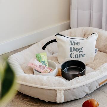 a dog bed with food and a bag on it