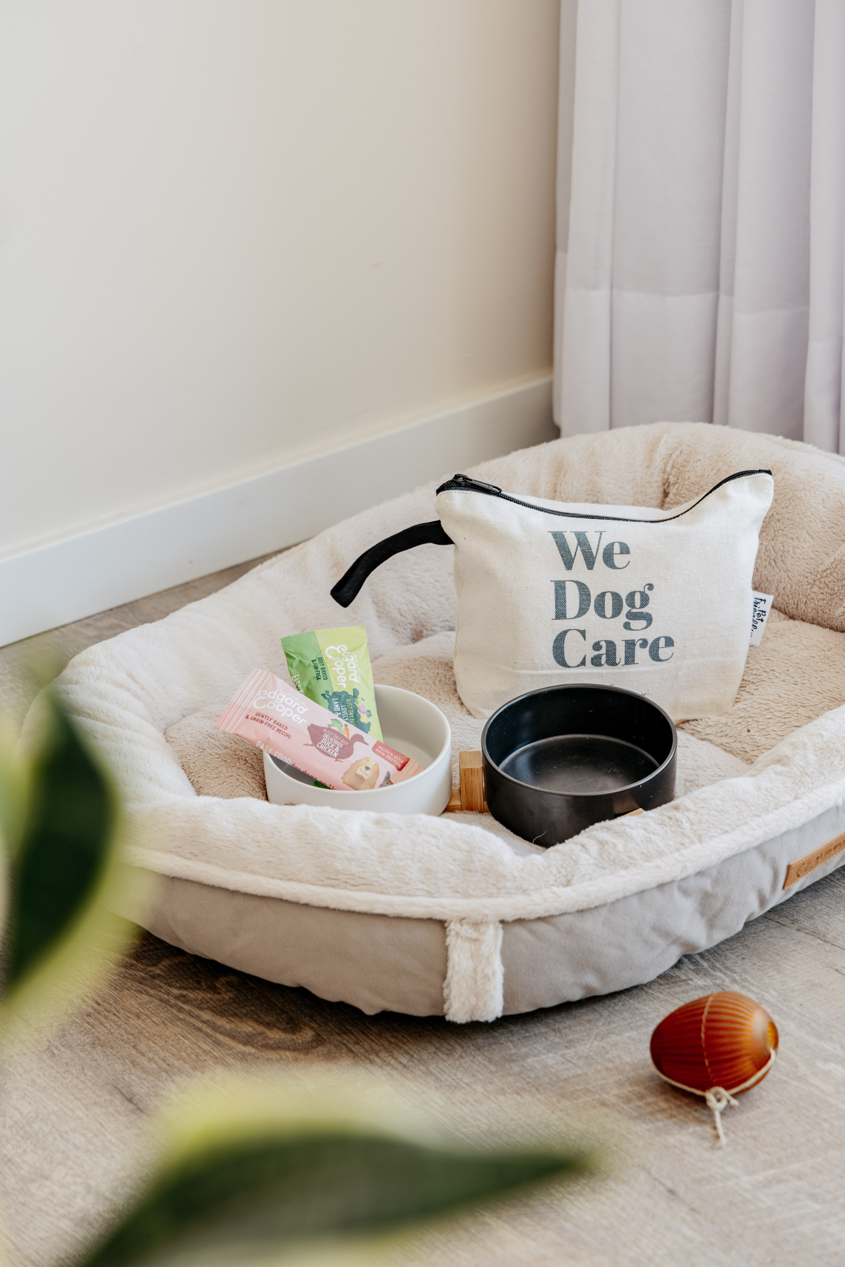 Soft dog bed, "We Dog Care" pouch, Edgard Cooper treats, bowls, pet toy.