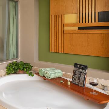 a bathtub with a glass of wine on it