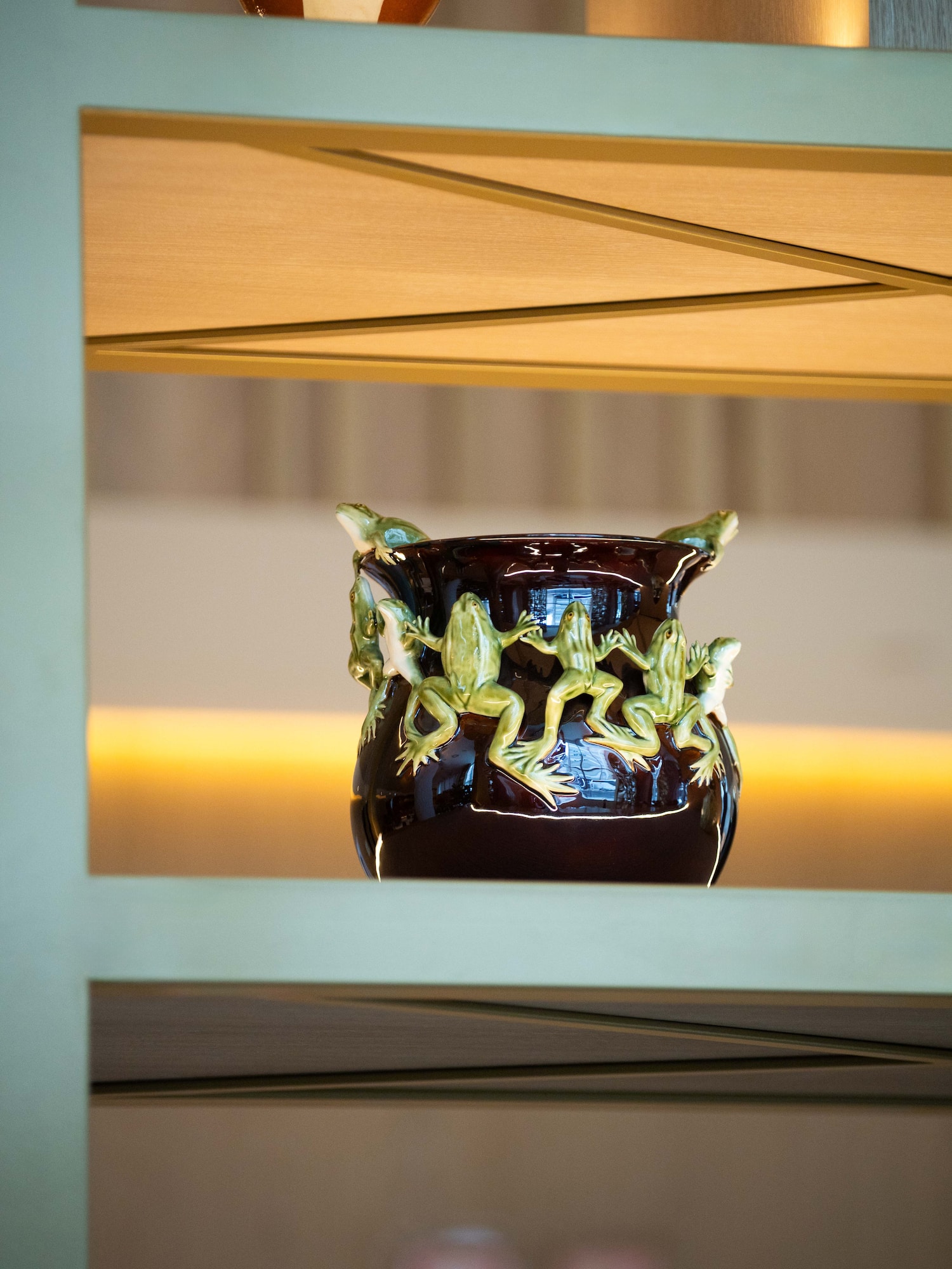 a ceramic vase with frogs on it