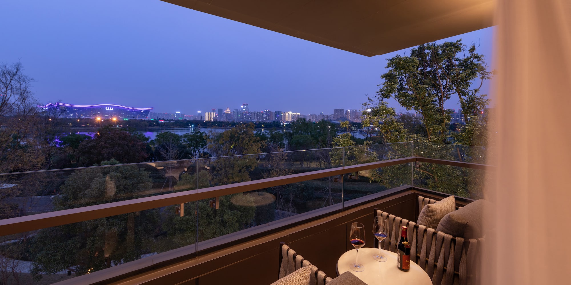 a balcony with a table and chairs and a city view