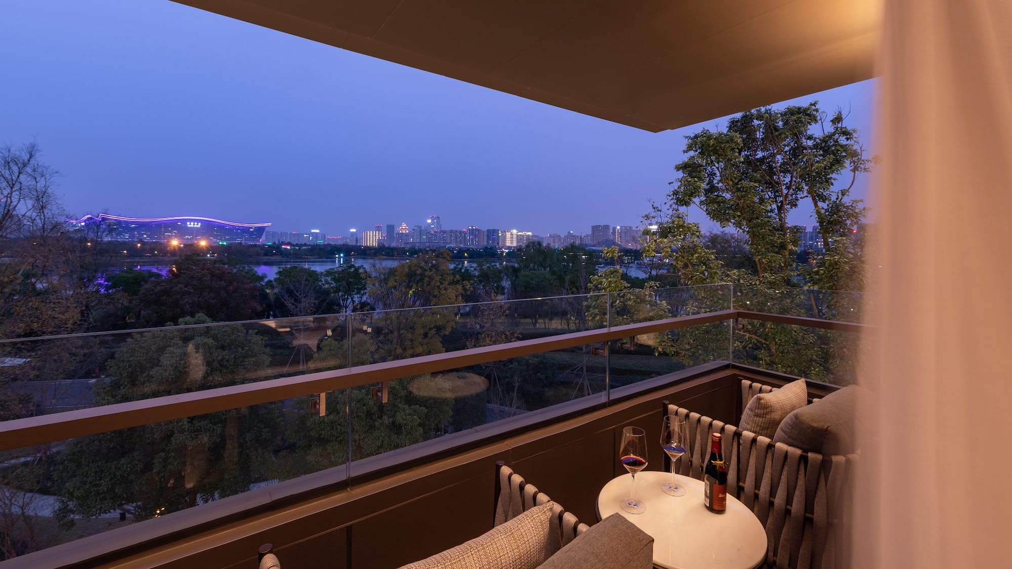 a balcony with a table and chairs and a city view