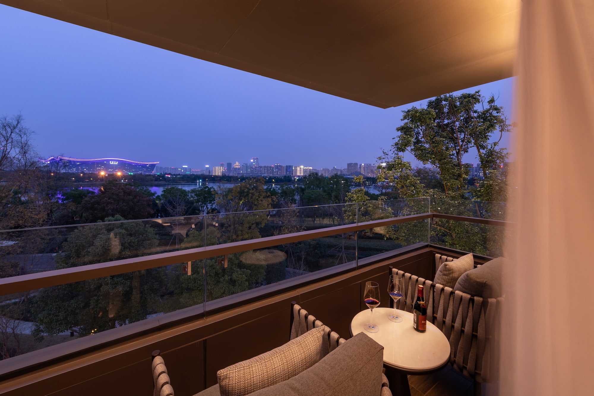 a balcony with a table and chairs and a city view