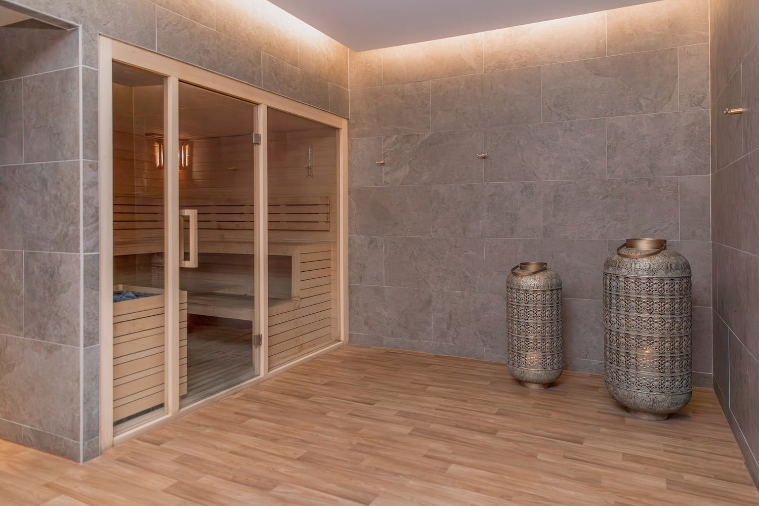 a sauna room with two large jars and a glass door