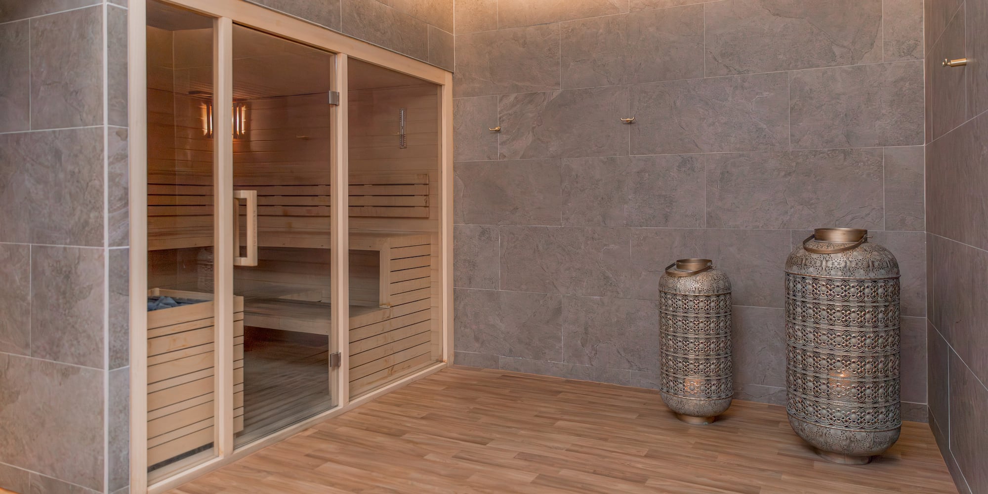 a sauna room with two large jars and a glass door