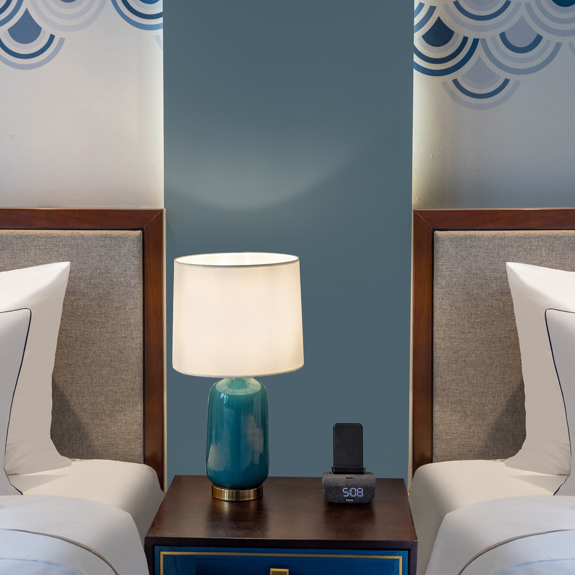 a lamp on a table next to two beds