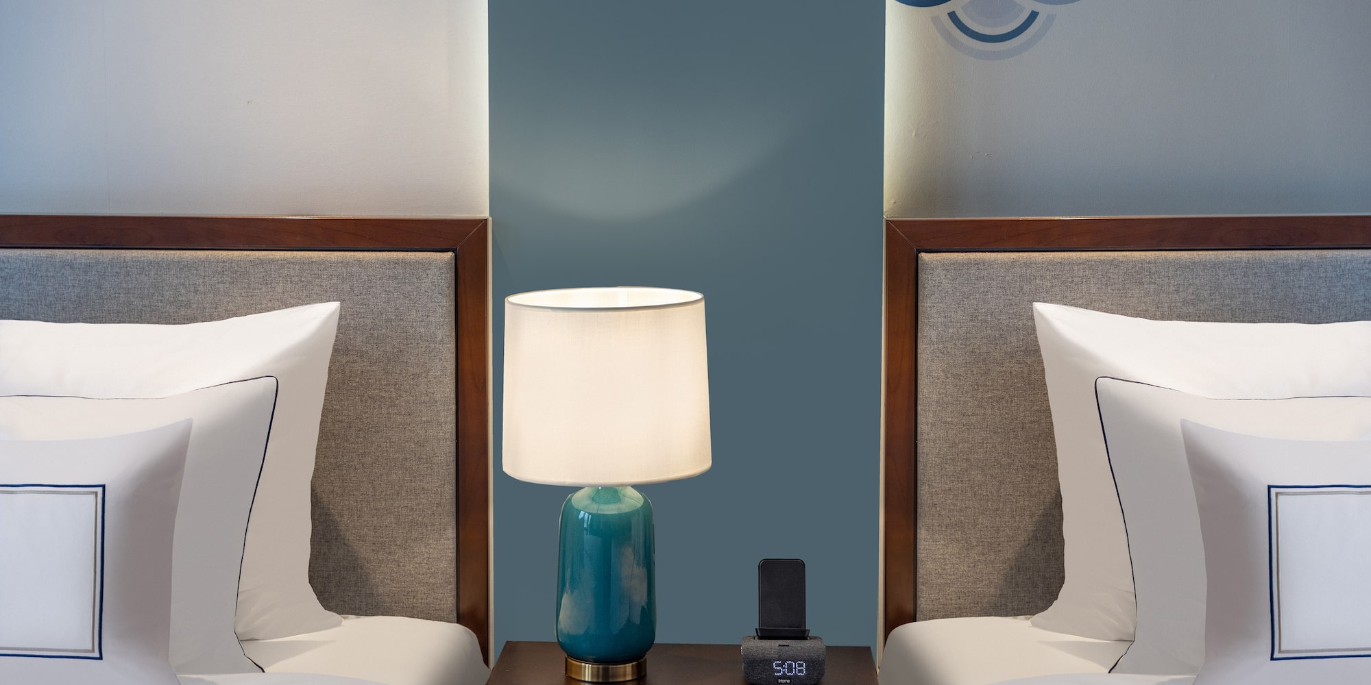 a lamp on a table next to two beds