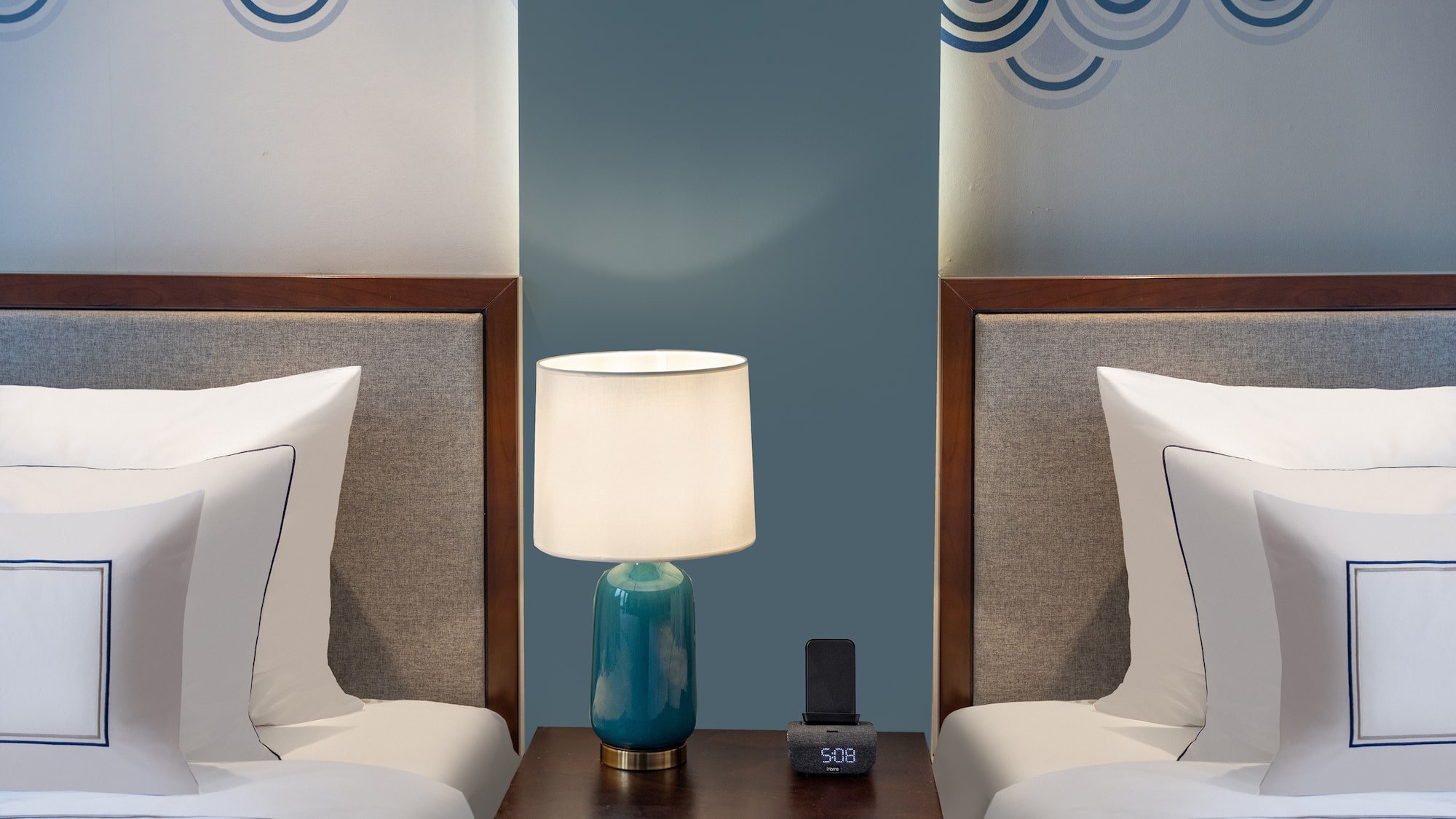 a lamp on a table next to two beds