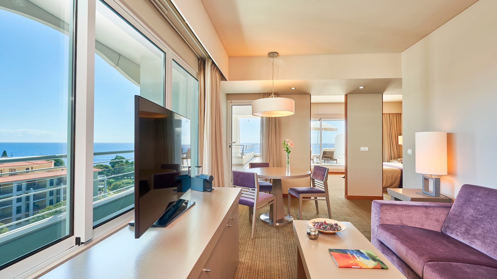 a room with a television and a table and chairs