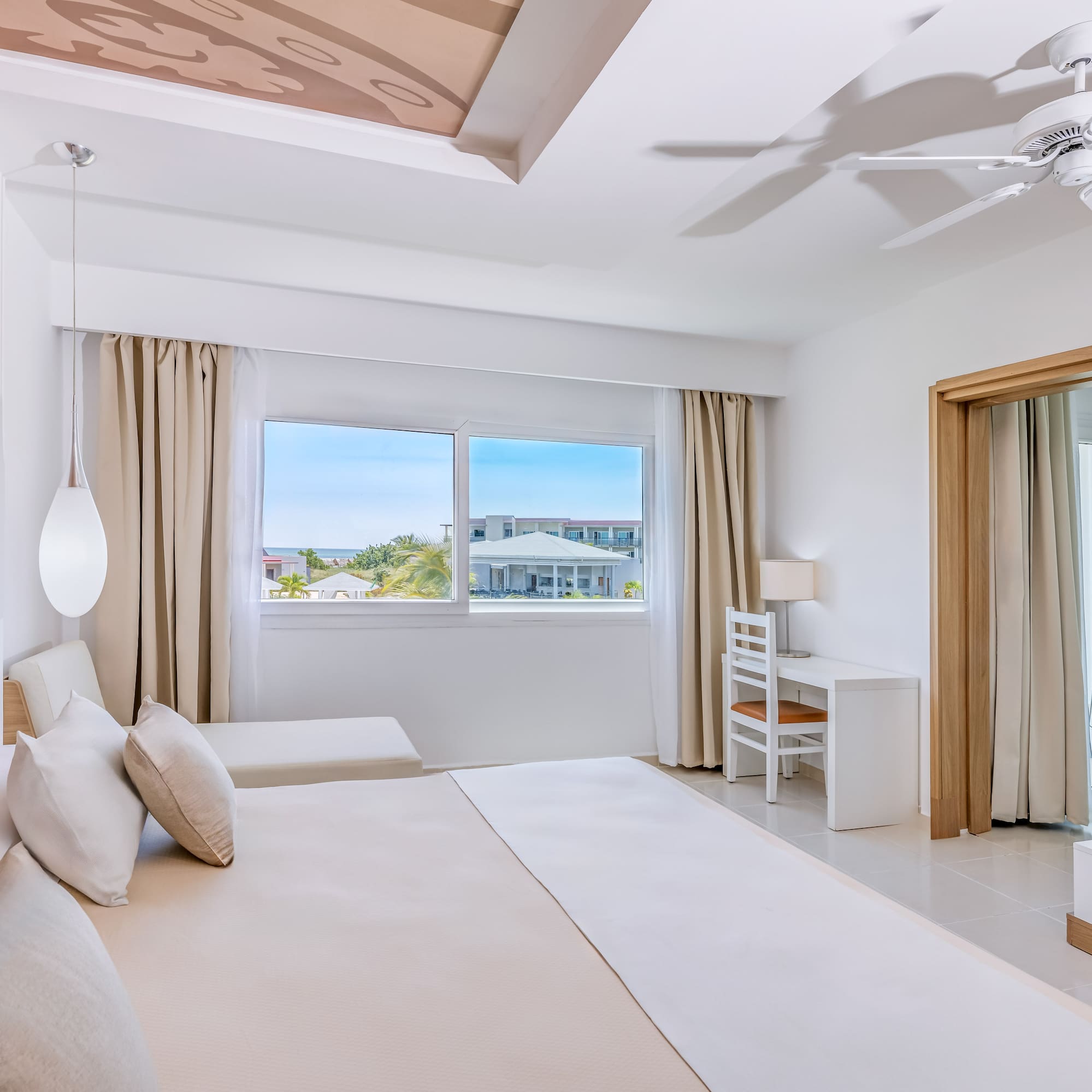 a bedroom with a large bed and a ceiling fan