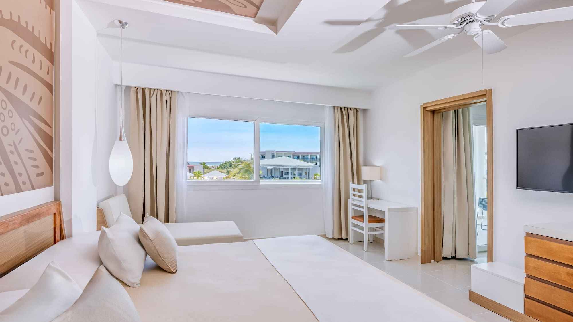 a bedroom with a large bed and a ceiling fan