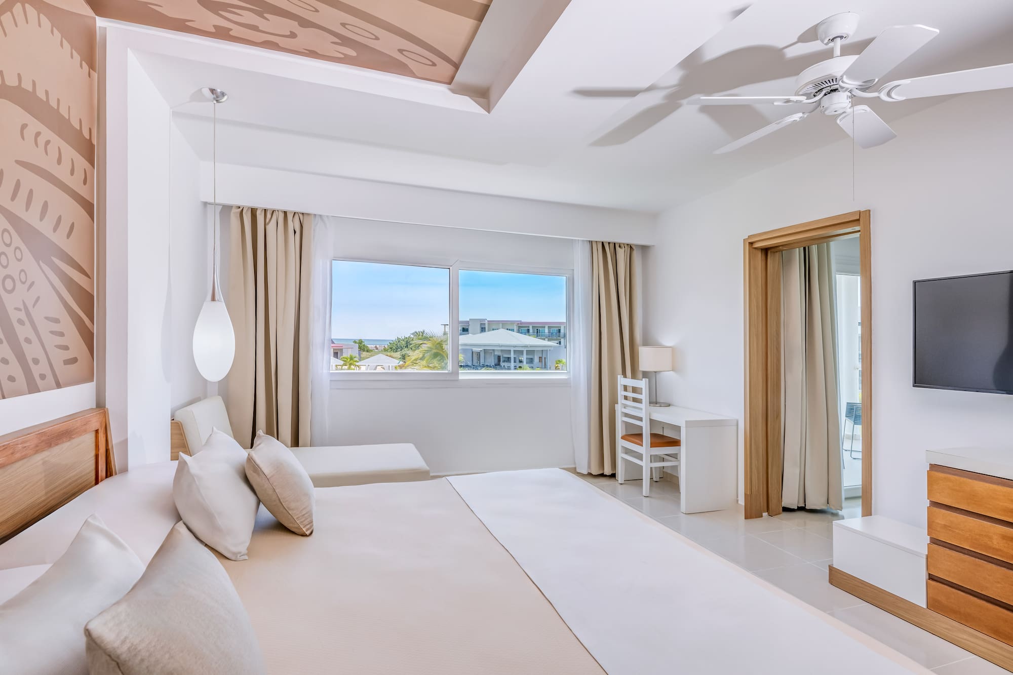 a bedroom with a large bed and a ceiling fan