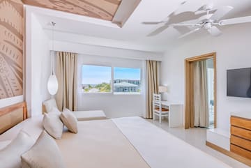a bedroom with a large bed and a ceiling fan