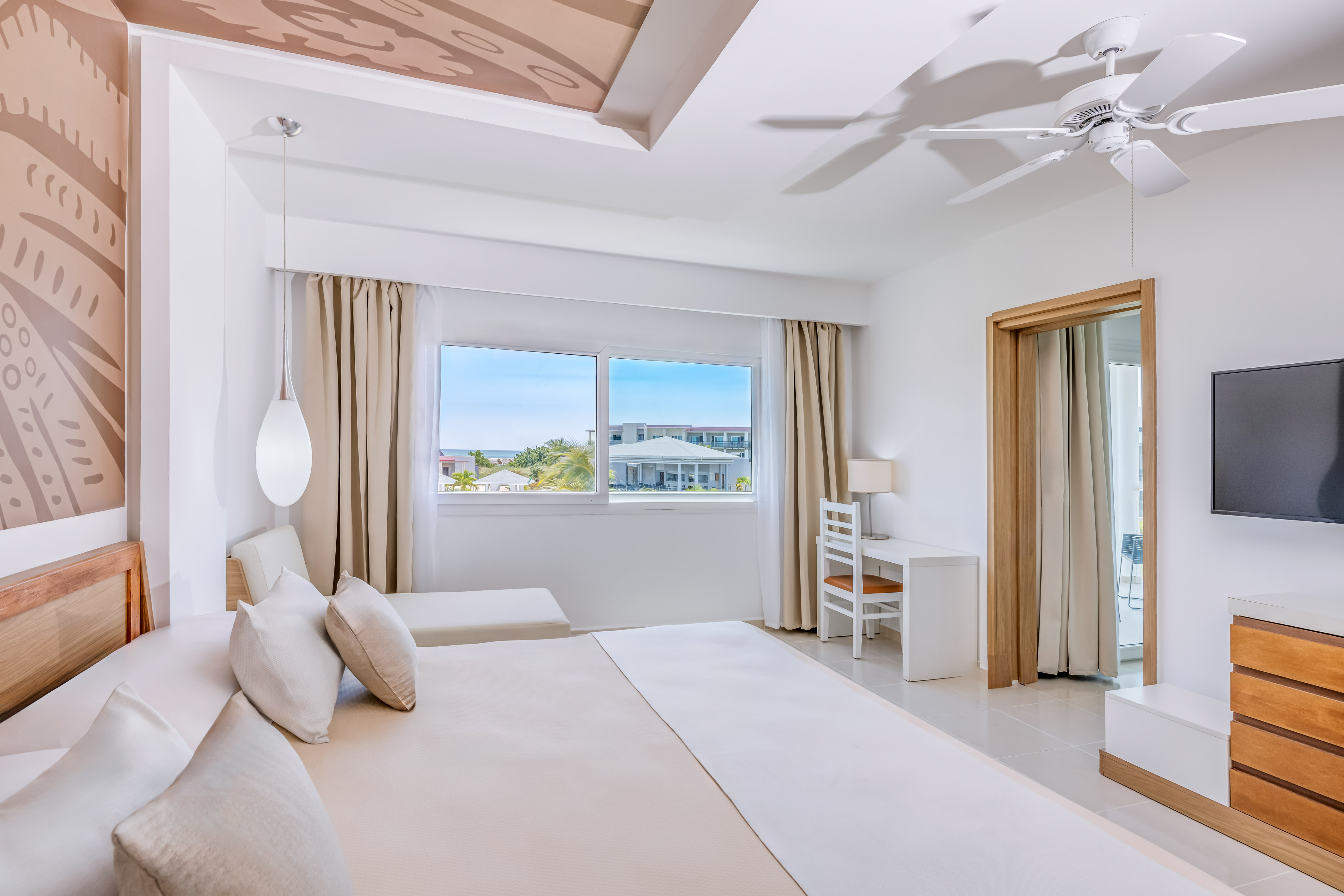 a bedroom with a large bed and a ceiling fan