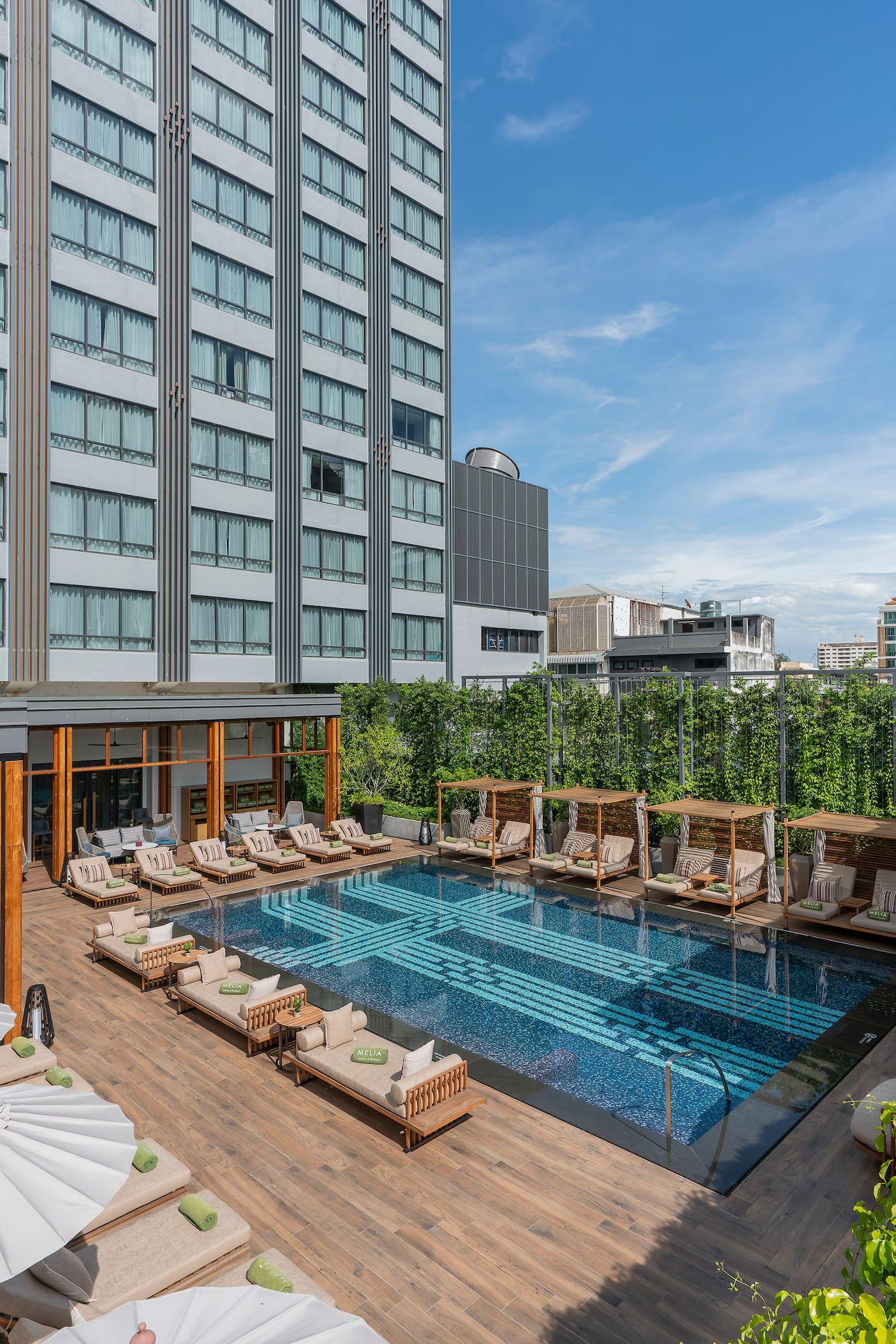 a pool with chairs and a building in the background