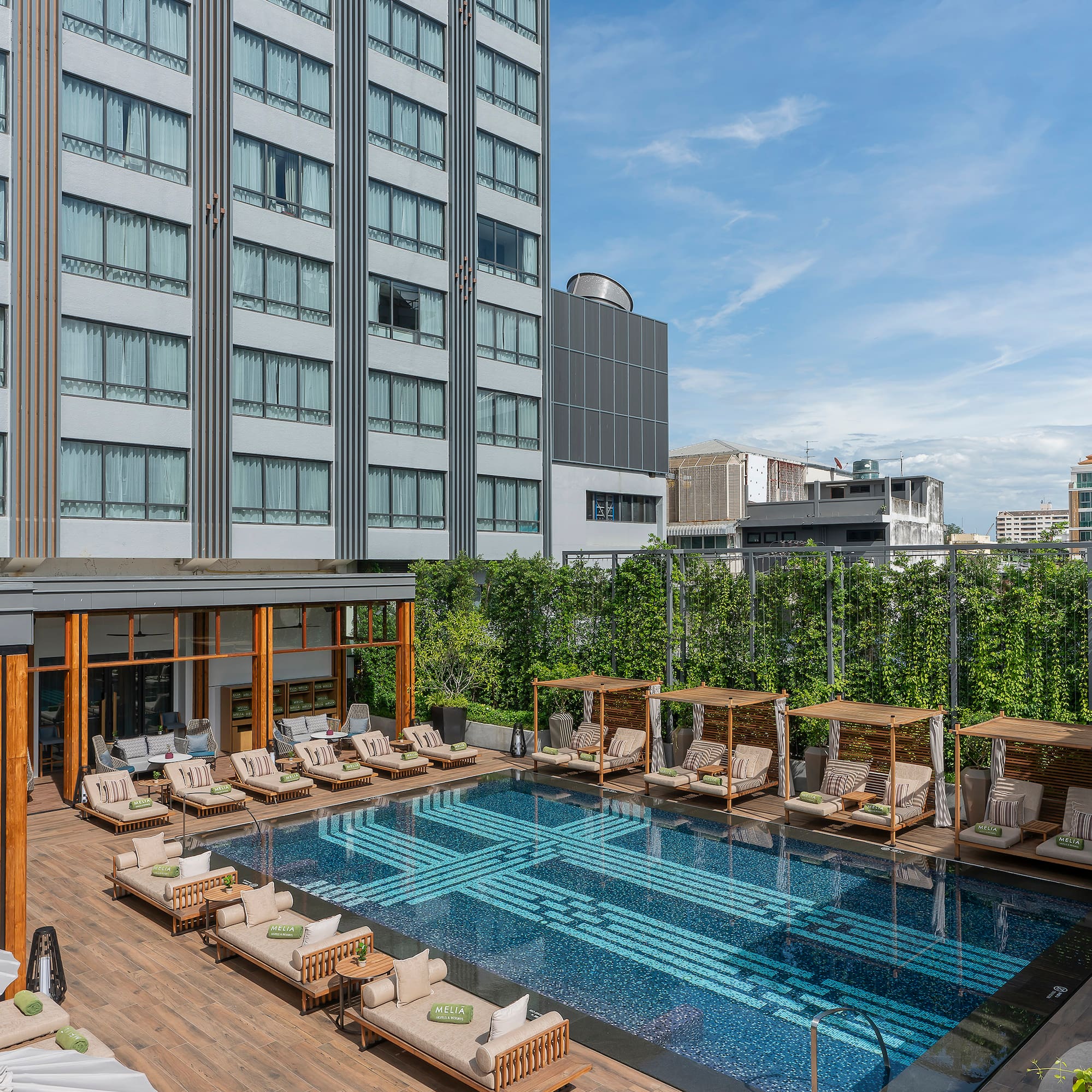 a pool with chairs and a building in the background