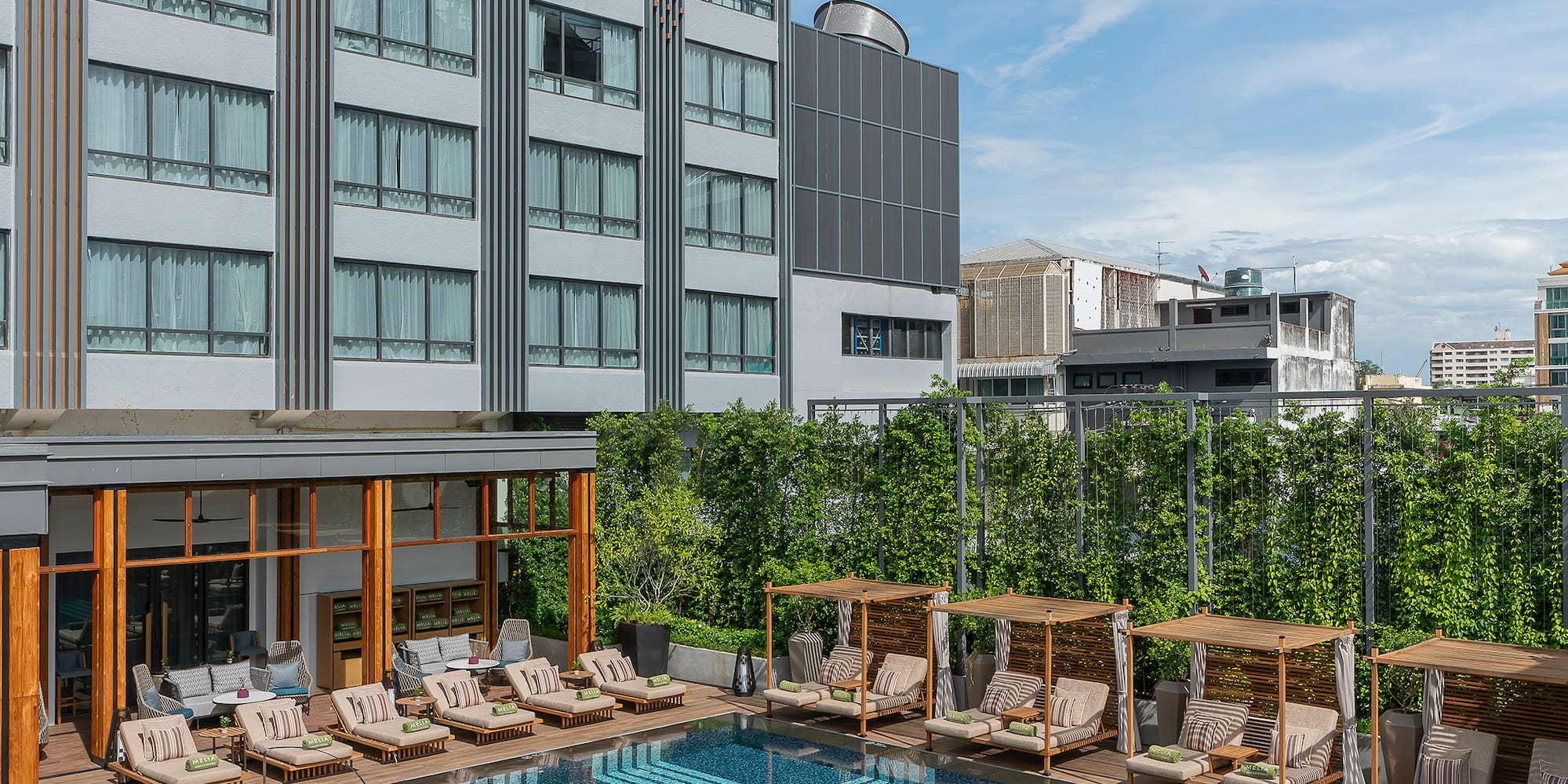 a pool with chairs and a building in the background