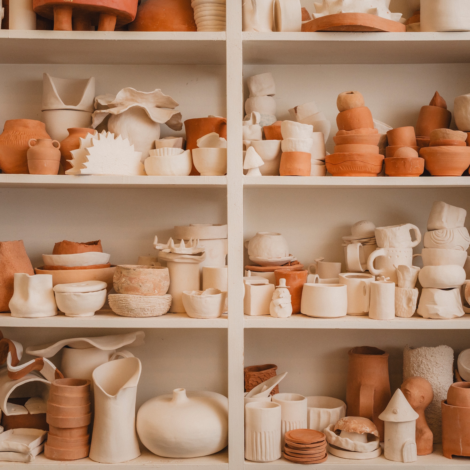 a shelf full of clay objects