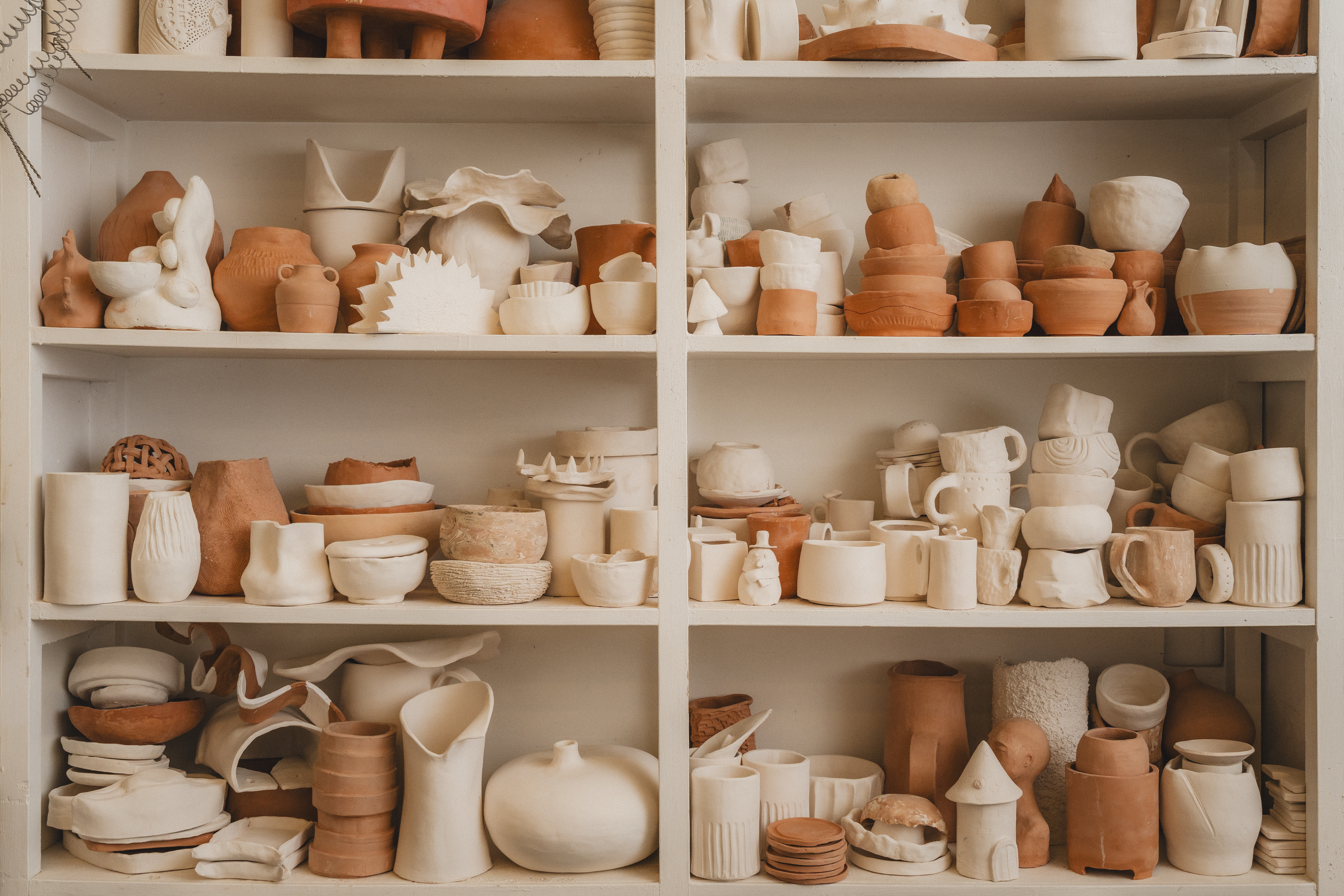 a shelf full of clay objects