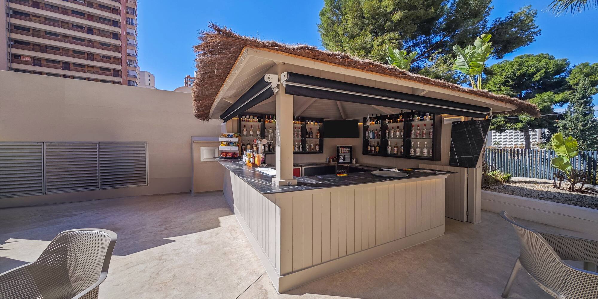 a bar outside with a straw roof