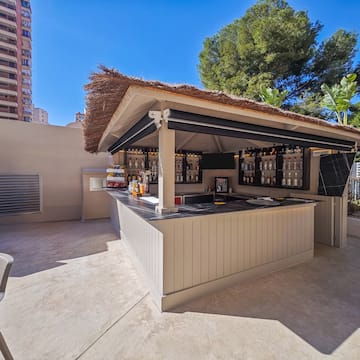 a bar outside with a straw roof