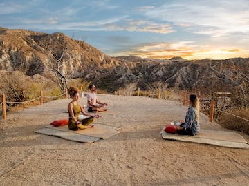 a group of people sitting on mats in a desert