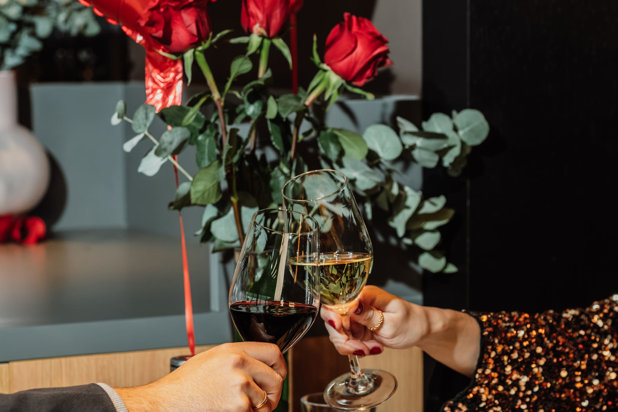 a couple holding wine glasses and a red balloon