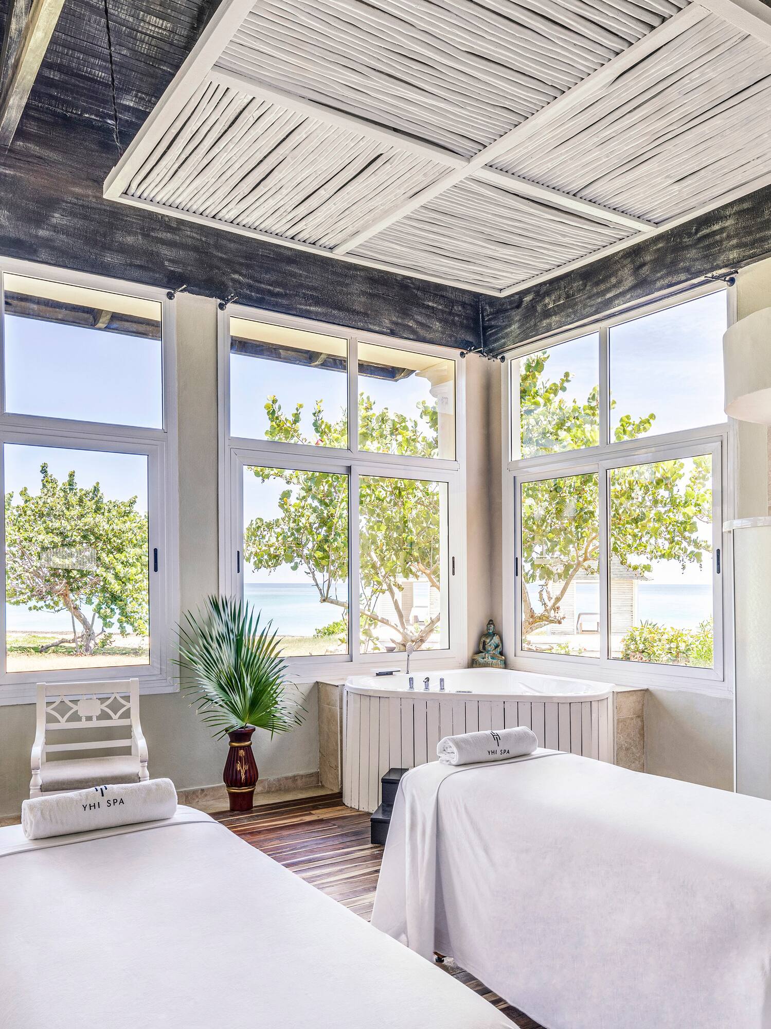 a room with white beds and windows