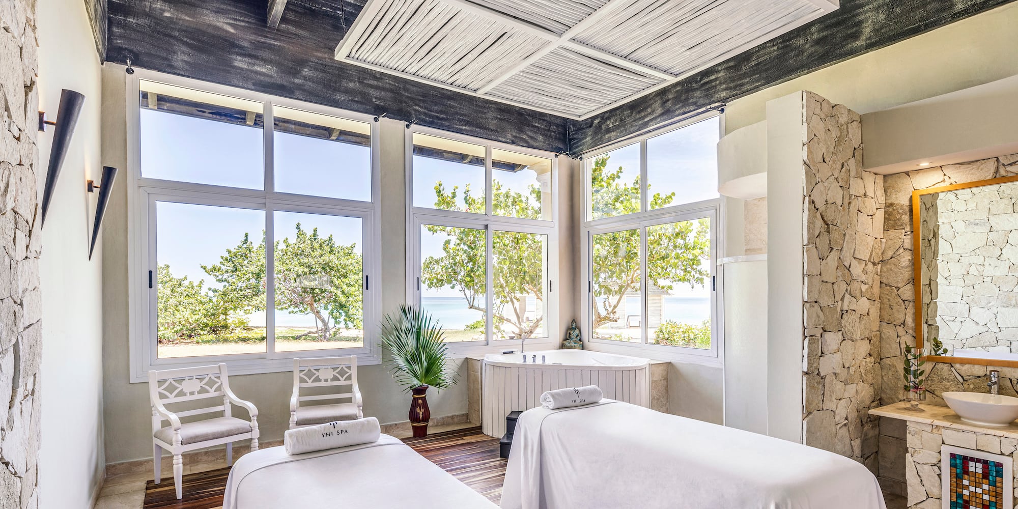 a room with white beds and windows