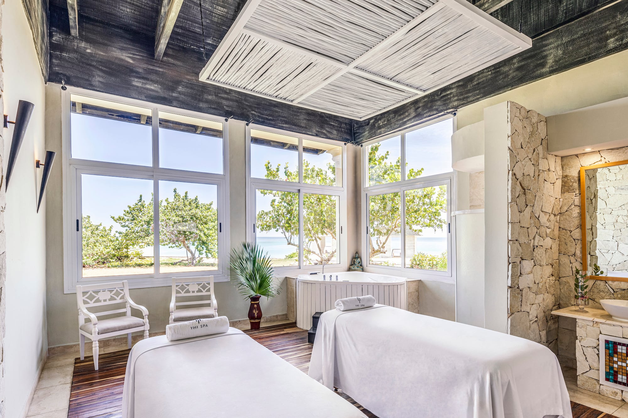 a room with white beds and windows