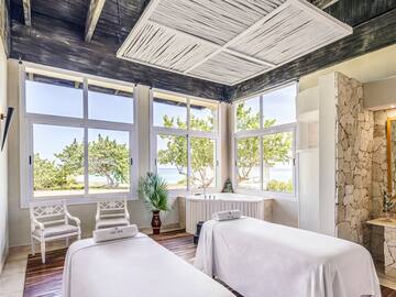 a room with white beds and windows