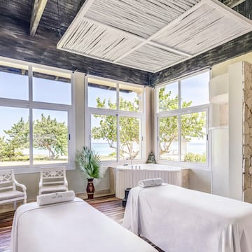 a room with white beds and windows