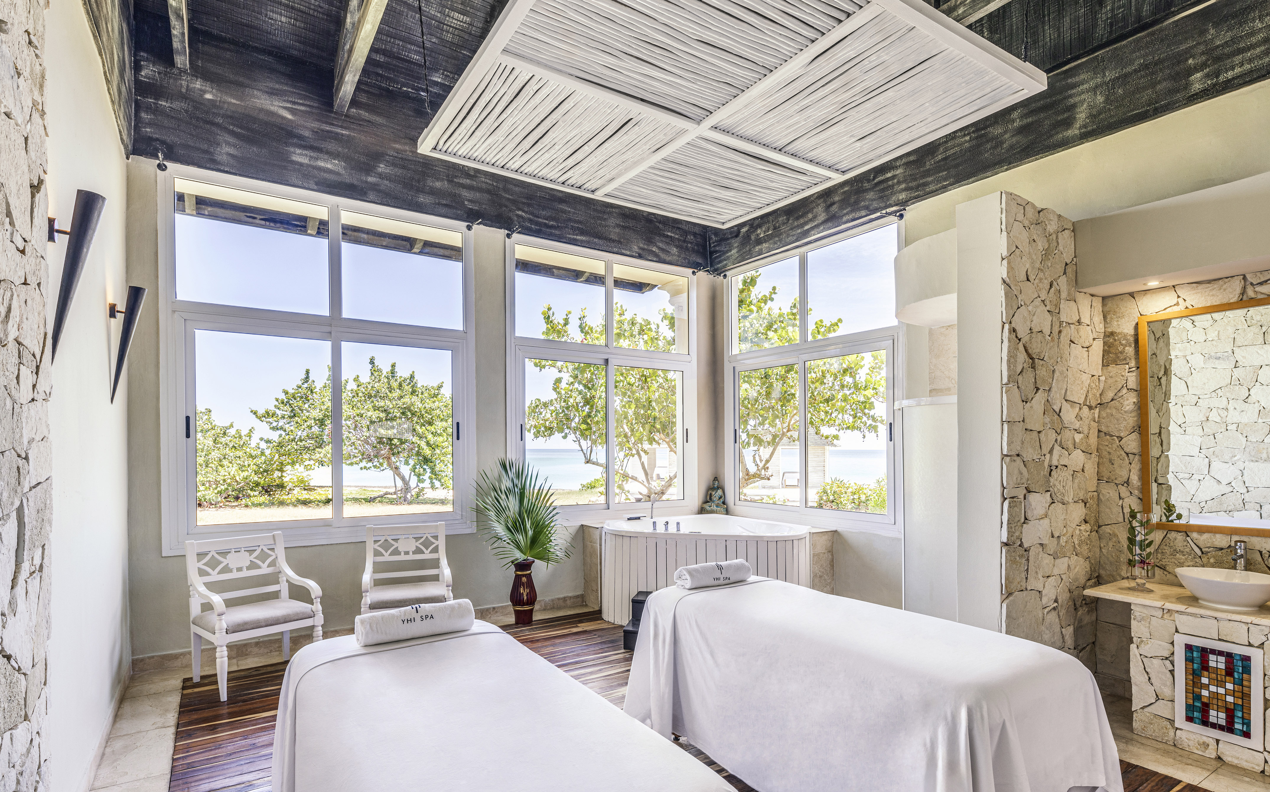 a room with white beds and windows