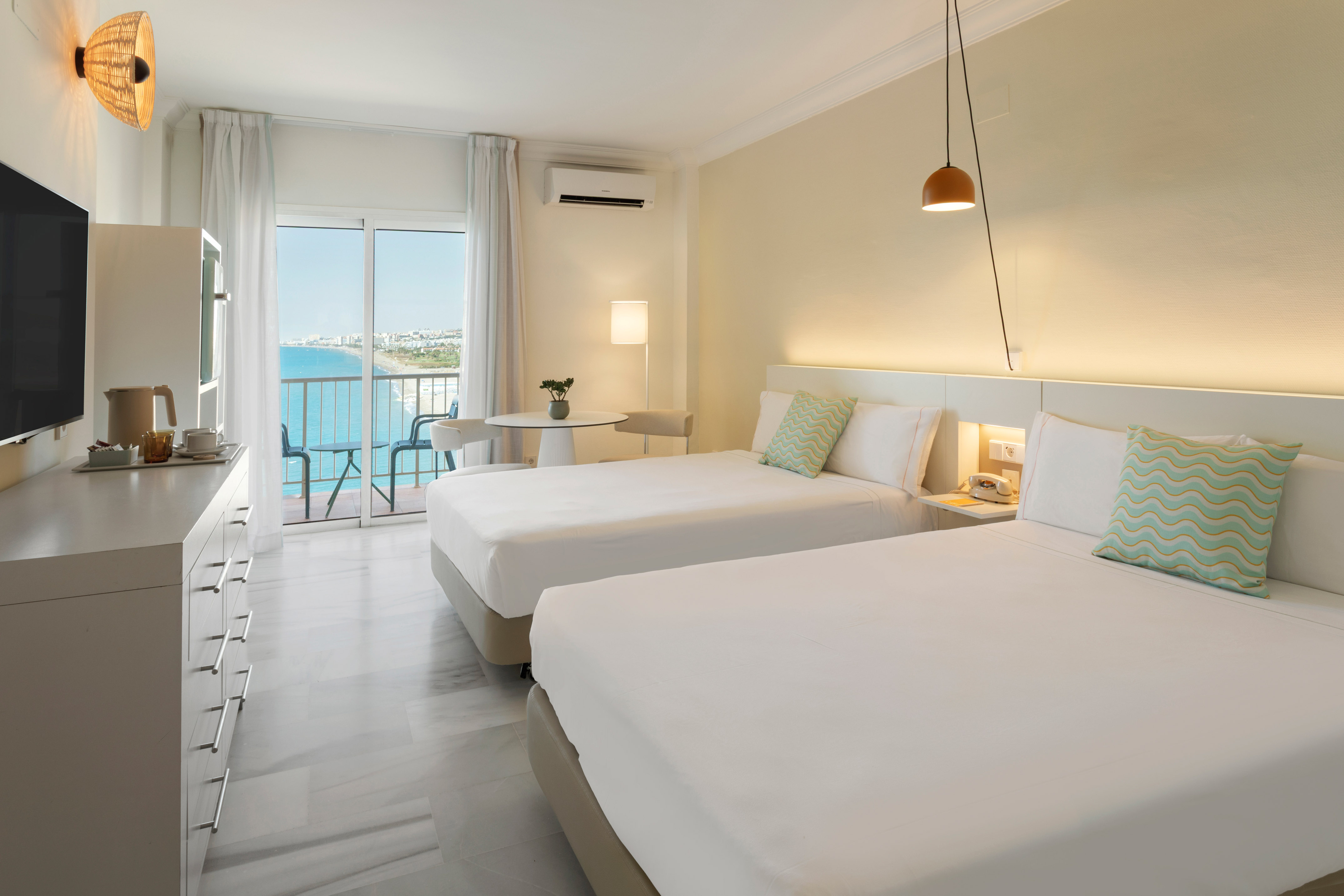 a room with two beds and a television and a window