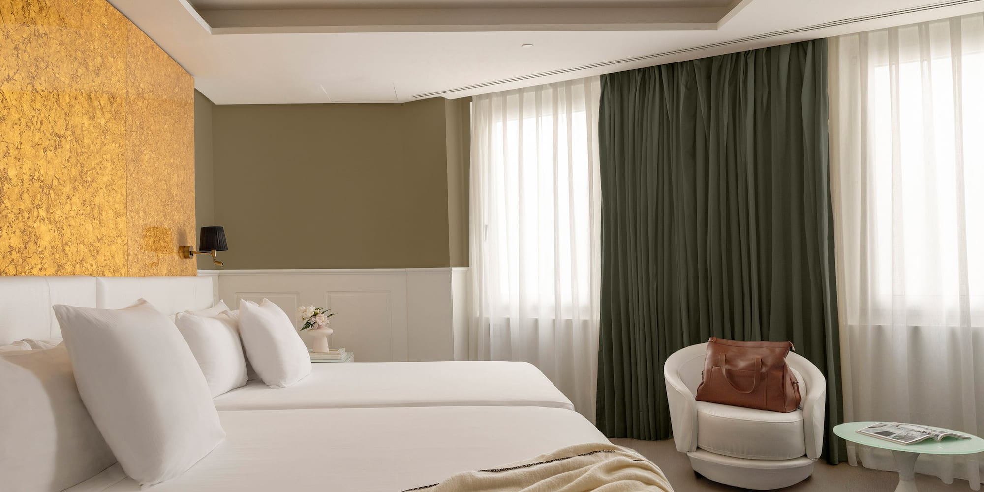 a room with white beds and a chair