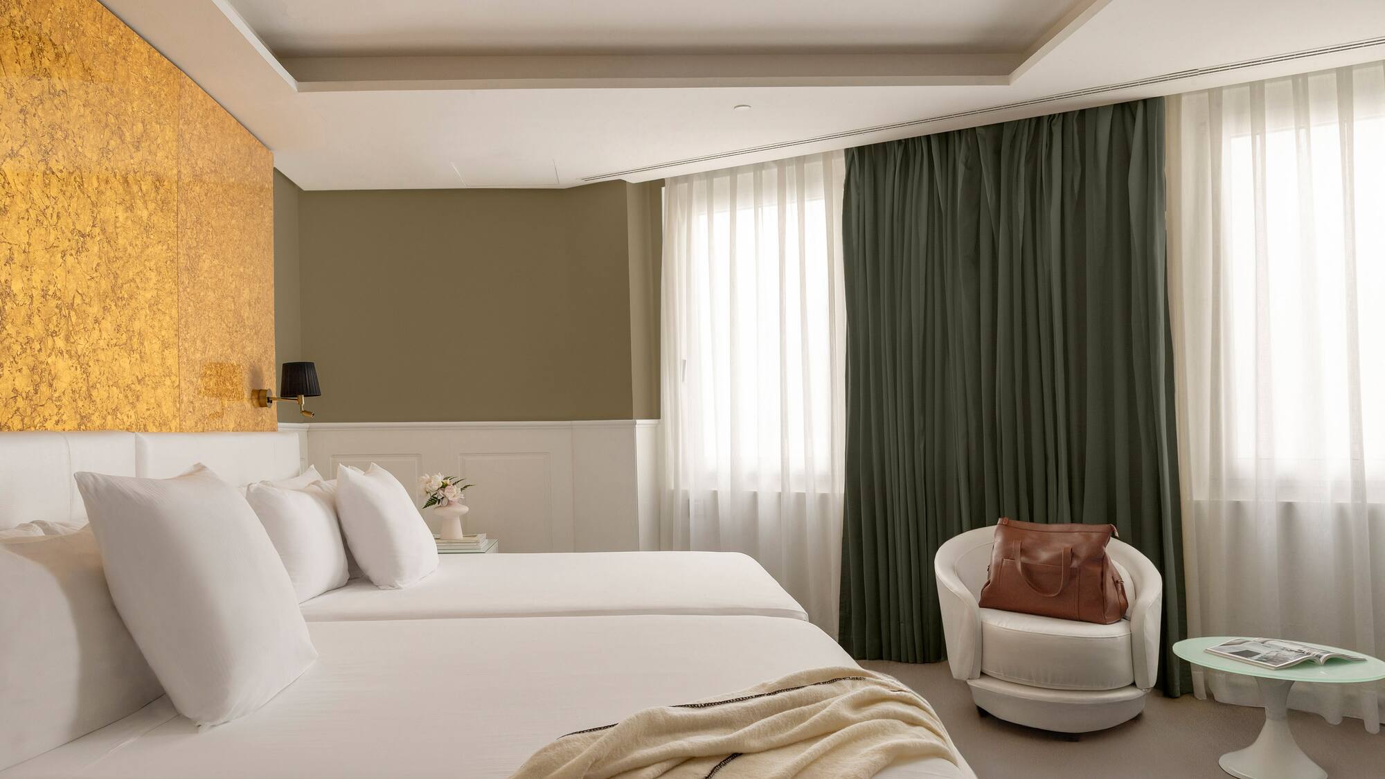 a room with white beds and a chair