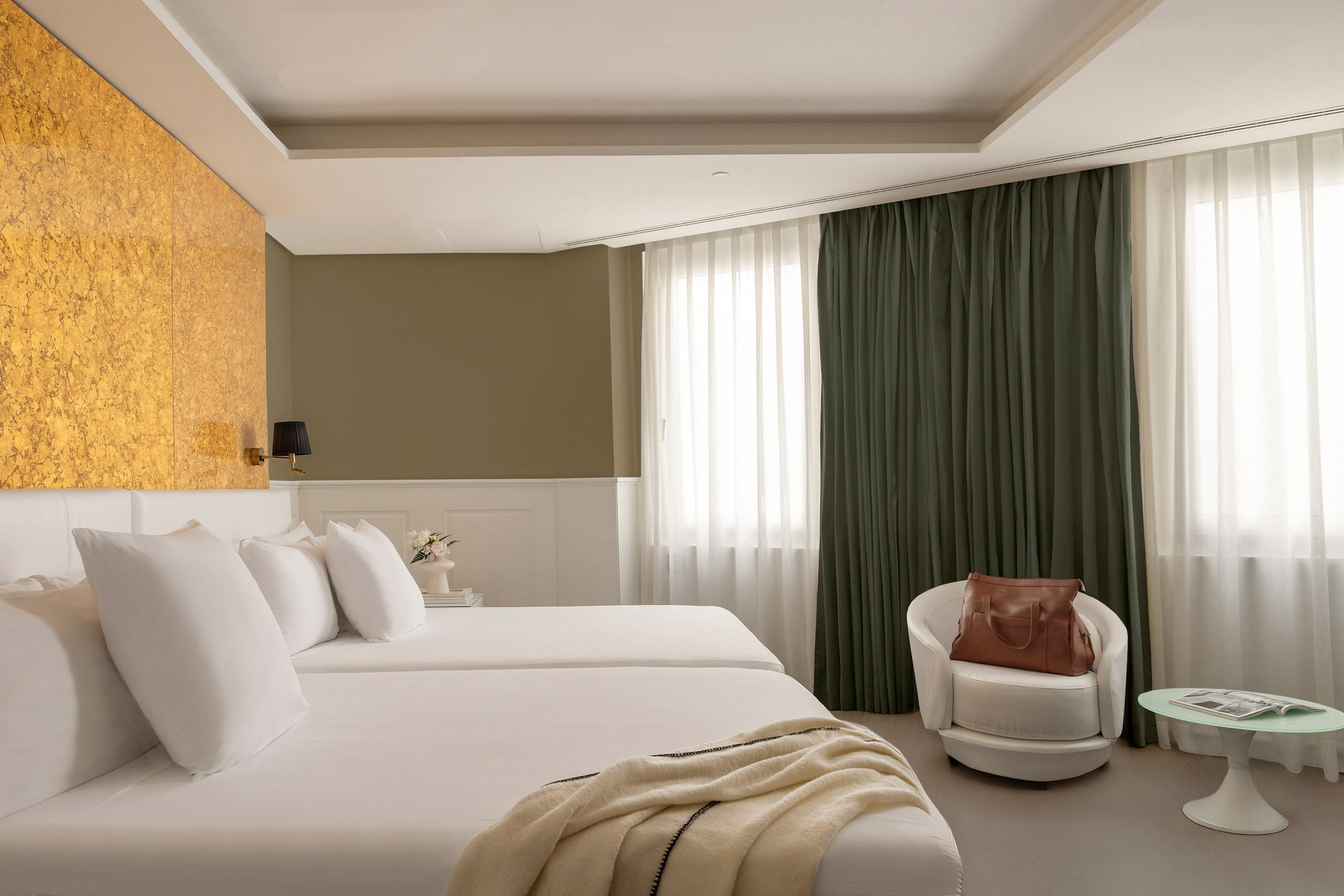 a room with white beds and a chair