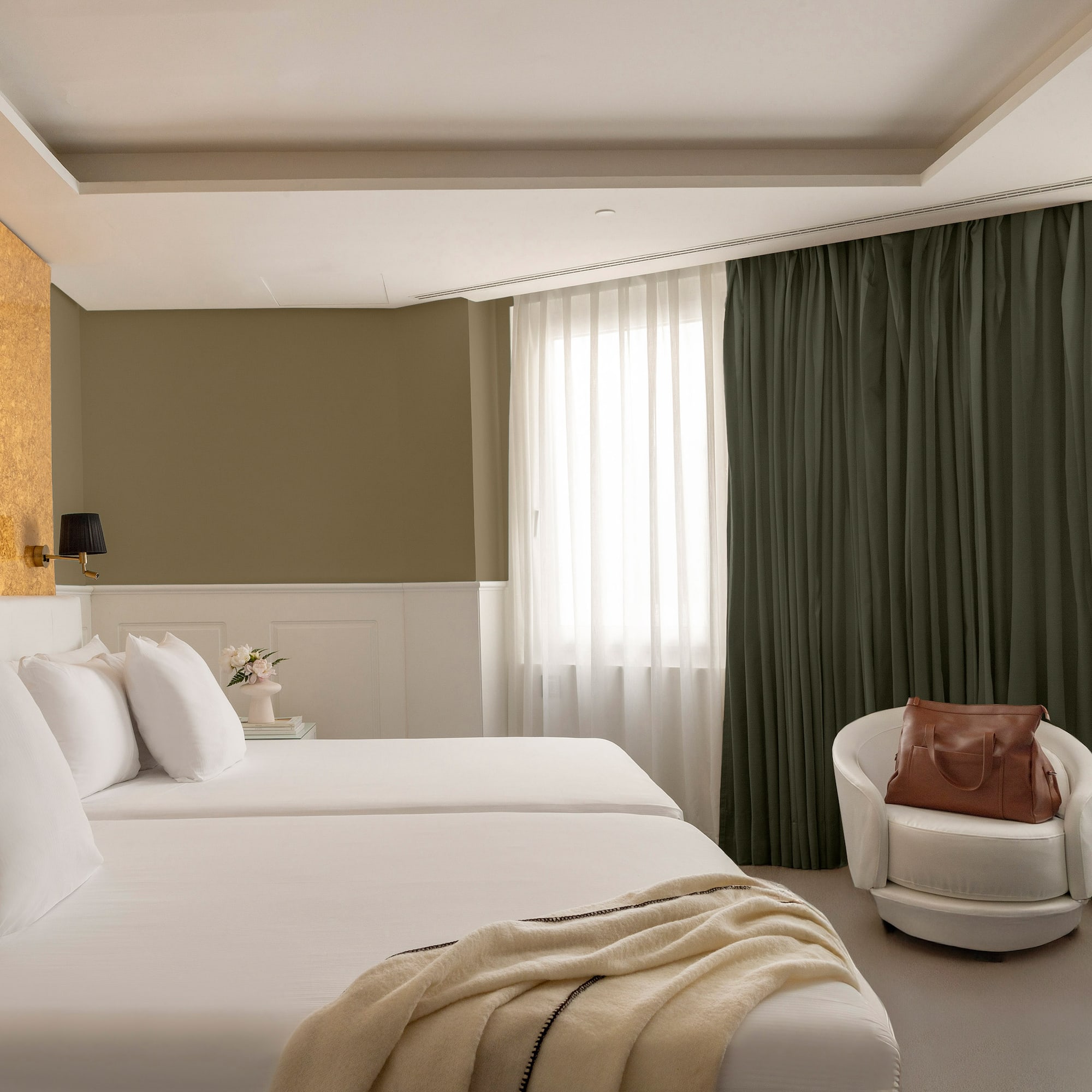 a room with white beds and a chair